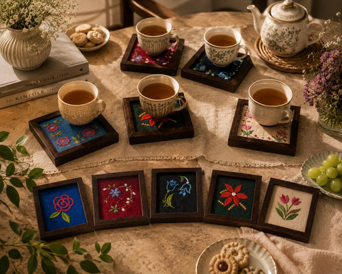 Aavo hand embroidered coasters grouped on a table with cups of tea