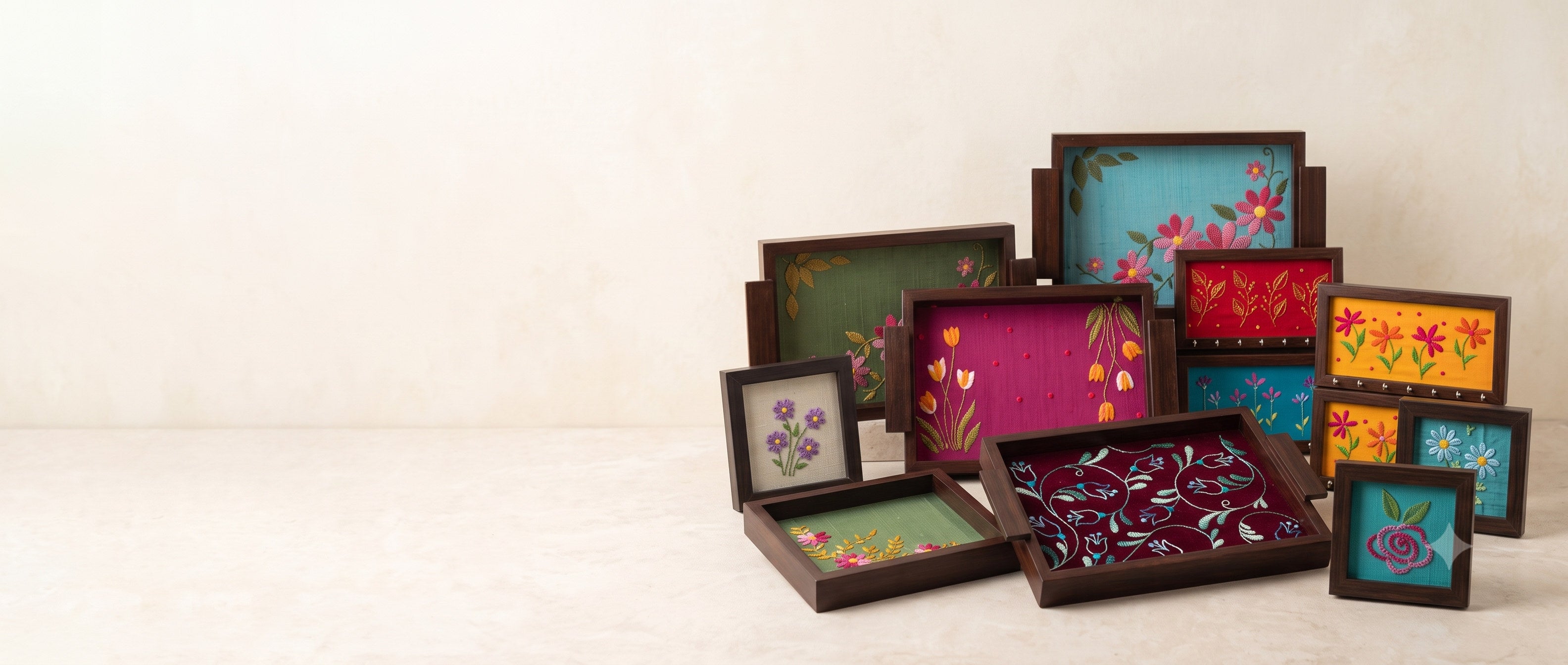 Aavo hand embroidered trays, coasters and key holders arranged on a pale background