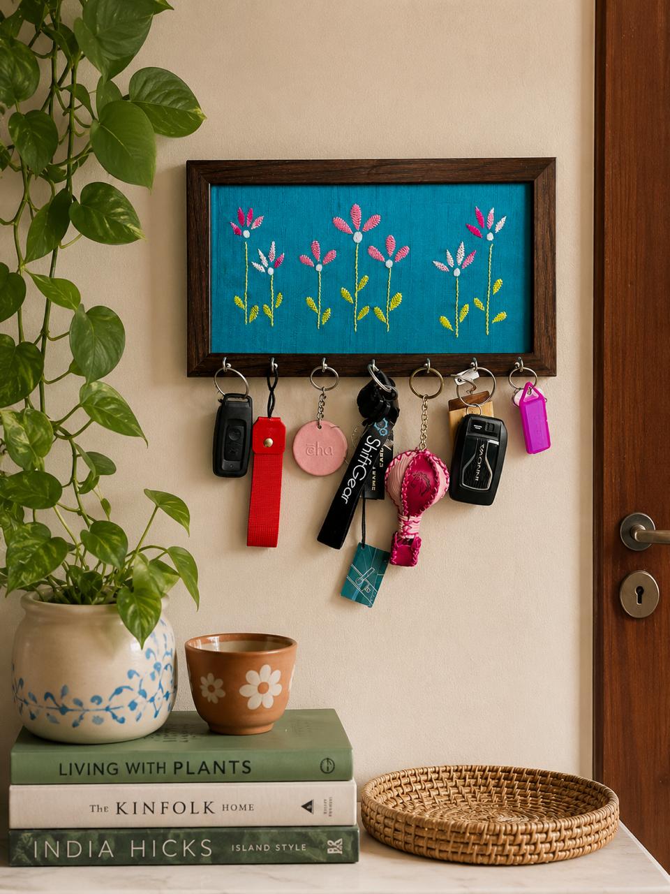 Aavo hand embroidered key holder mounted by a doorway with keys hanging